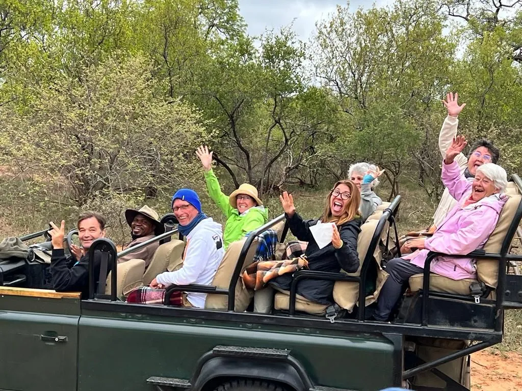 Group of people enjoying a safari ride in an open vehicle.